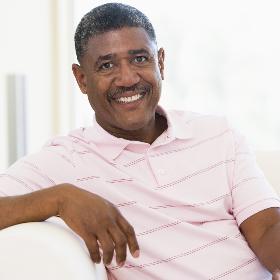 Hombre sentado en un sofá leyendo a